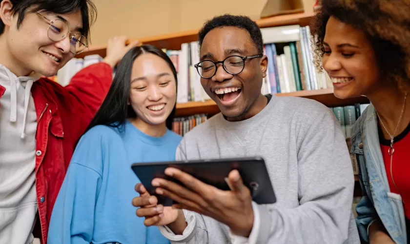 Studenten die naast elkaar staan en op een tablet iets bekijken